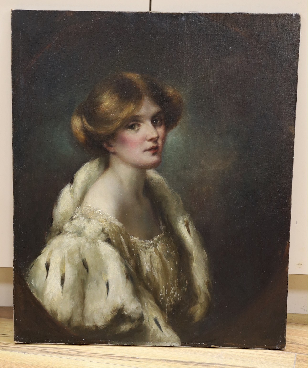 English School c.1900, oil on canvas, Portrait of a young lady wearing an ermine trimmed cape, painted to the oval, 77 x 64cm, unframed